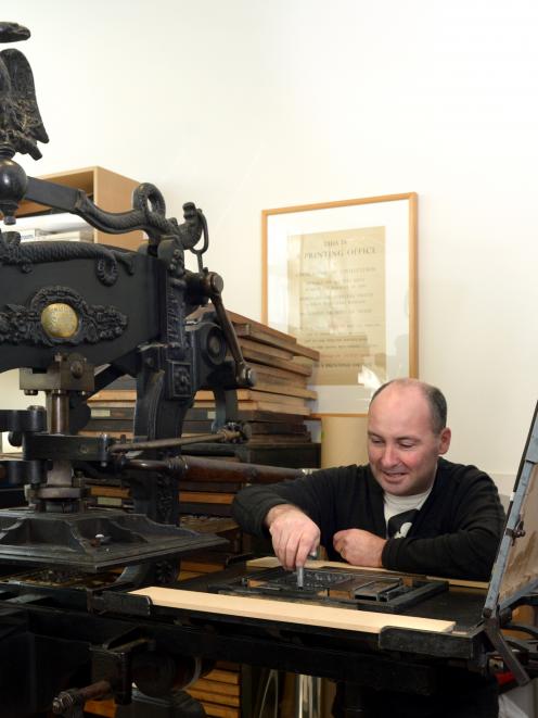 Otakou Press printer in residence Peter Vangioni works on the Columbian Eagle press in the...