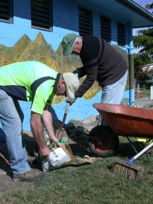 Otematata residents Rob Armstrong (left) and Graham Sullivan clear smashed beer and liquor...