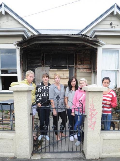 Outside their fire-damaged flat are University of Otago students (from left) Phoebe Roche (22),...