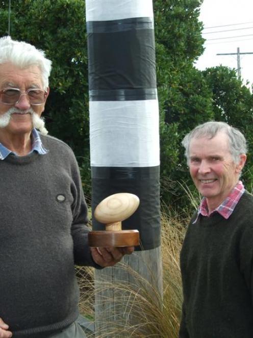 Owaka wood-carver Alex Black, with one of the two trophies he made for a planned rugby...