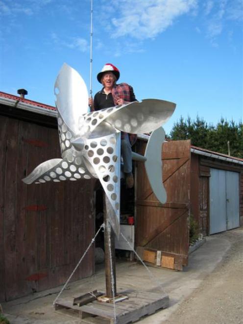 Going for a spin . . . Wind power enthusiast John McCabe shows his new wind turbine sculpture,...