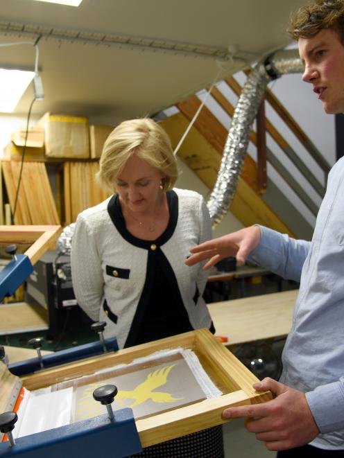 Chris Bran shows Communications Minister Amy Adams his South Dunedin screen-printing business,...