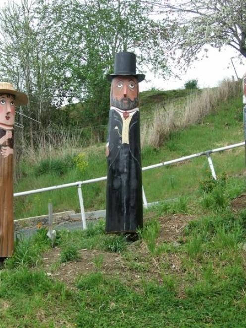 Painted wooden characters of Helen Munro, Gabriel Read (centre), and Black Peter, in Lawrence....