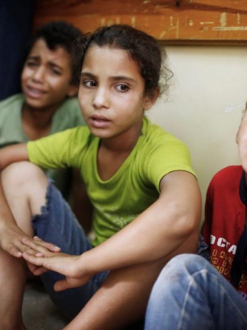 Palestinian children who fled what medics said was Israeli shelling that hit a UN-run school...