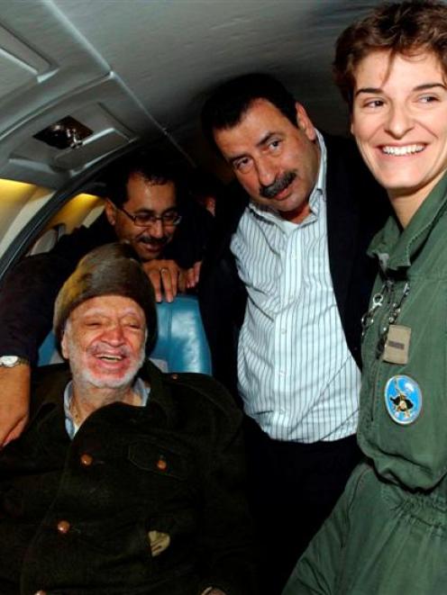 Palestinian leader Yasser Arafat sits in a plane as he heads to France for medical treatment in...