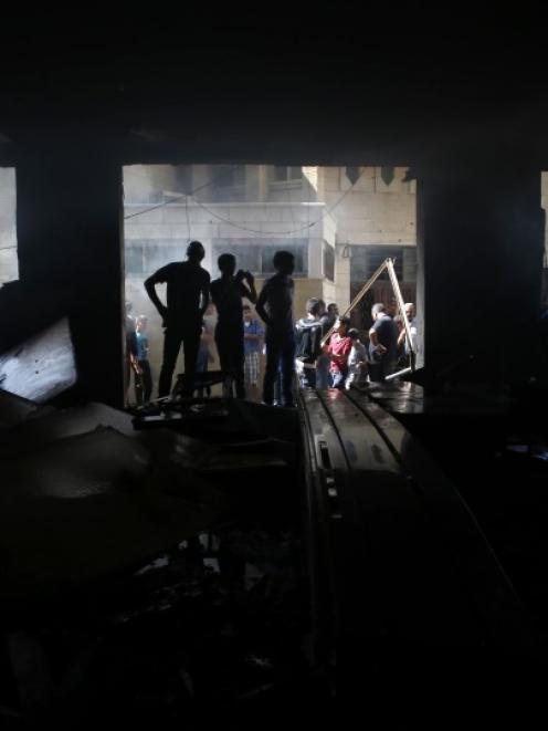 Palestinians gather at the scene where Israeli troops shot dead two Palestinians, Marwan Kawasme...
