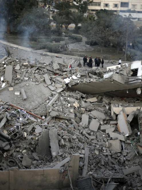 Palestinians inspect the destroyed office building of Hamas Prime Minister Ismail Haniyeh in Gaza...