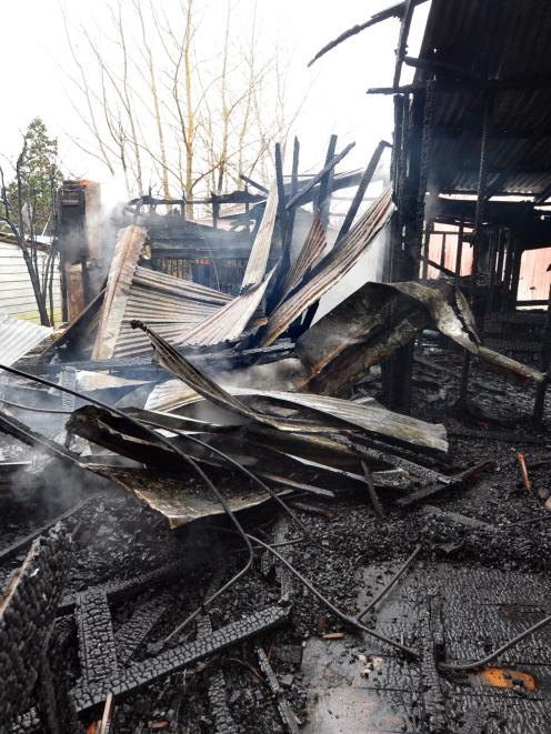 Palmerston volunteer firefighter Aaron Frederick checks for hot spots yesterday. Photo by Stephen...