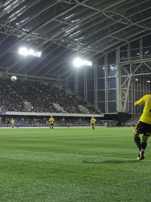 Part of the 15,000 crowd watches Leo Bertos taking a corner for the Wellington Phoenix against...