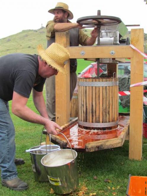 Partners in a new company Jim Howden (rear) and Quentin Barrow operate a home-built cider press...