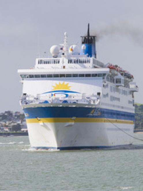 The cruise ship, Pacific Sun, is helped into berth by tugs