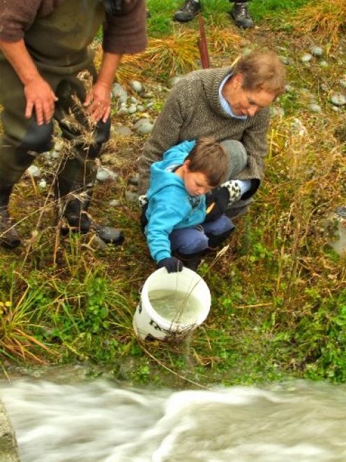 Patricia Baker and her grandson Oliver Lienert (3) liberate the first salmon smolt into the...