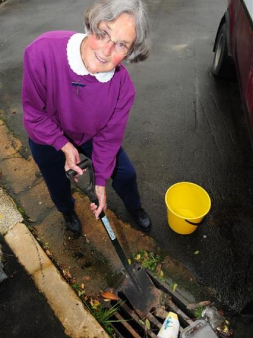 Patricia Lainchloury cleans a mud trap in McGlashan St, Woodhaugh. Photo by Craig Baxter.