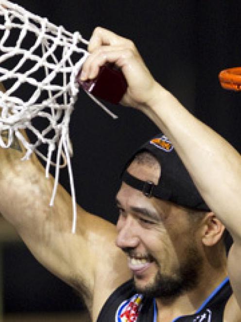 Paul Henare cuts the net to celebrate defeating the Taipans in the third and deciding grand final...