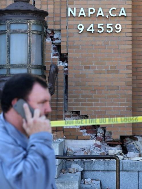 Pedestrians walk by the damaged Napa post office following the earthquake.  (Photo by Justin...