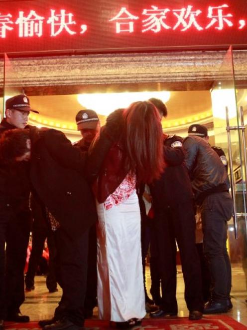 People are taken away during a police raid at a hotel, as part of the crackdown on prostitution...