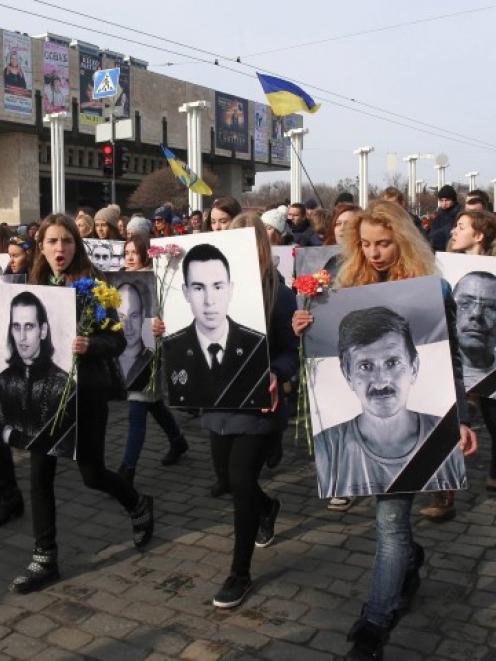 People carry portraits of local residents killed in fighting with pro-Russian separatists during...