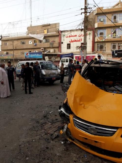 People gather at the site of a car bomb attack in Baghdad at the weekend. REUTERS/Thaier Al-Sudani