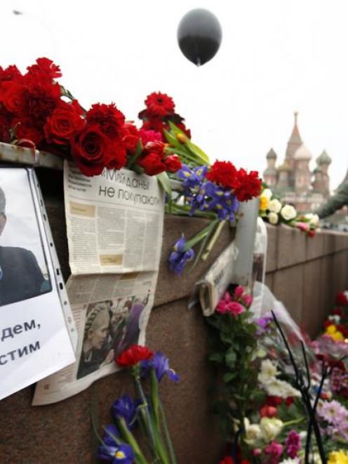 People gather at the site where Boris Nemtsov was murdered, in central Moscow, with St Basil's...