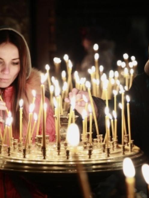 People light candles during a religious service at a church in Kiev.  REUTERS/David Mdzinarishvili