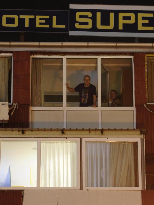 People look from the window of a quarantined hotel in Skopje. A British man showing symptoms of...