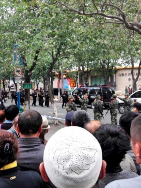 People look on at a street cordoned off by police after one of the blasts in Urumqi. REUTERS...