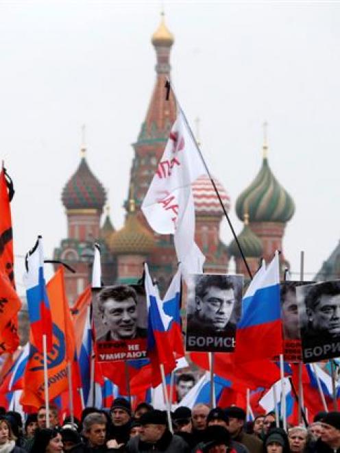 People march to commemorate Kremlin critic Boris Nemtsov near St. Basil's Cathedral in central...
