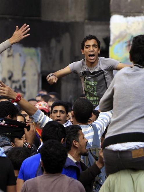 People protest to mark the one-year anniversary of fatal clashes on Mohamed Mahmoud Street, near...