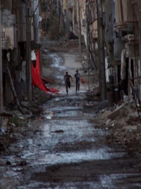 People run down a street in Deir al-Zor, Syria. REUTERS/Khalil Ashawi