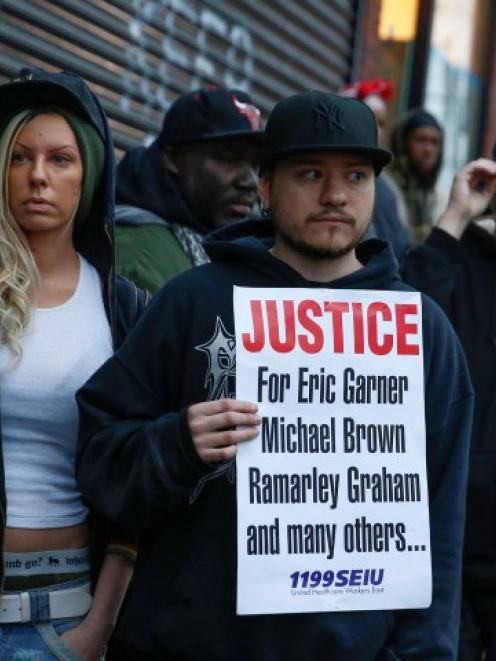 People stand next to a makeshift memorial where Eric Garner died during an arrest in July in...