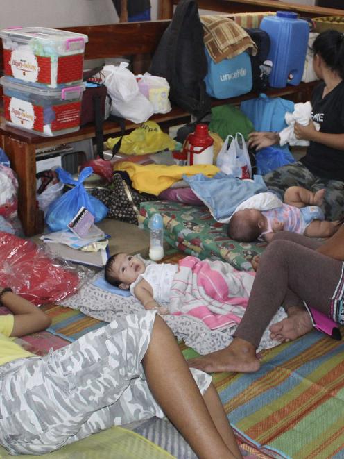 People take shelter inside a Catholic church after evacuating their homes due to super-typhoon...