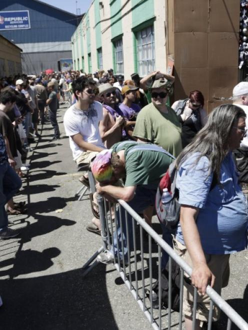 People wait in the heat to enter Cannabis City during the first day of legal retail marijuana...