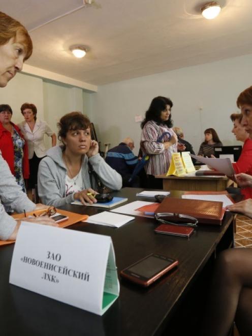 People, who have fled the fighting in the eastern regions of Ukraine, queue for job vacancies at...
