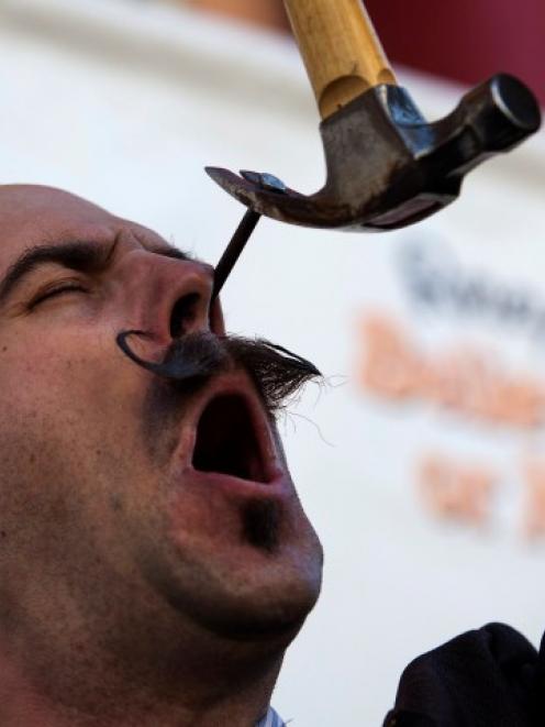 Performance artist Donny Vomit pulls a nail out of his nasal cavity ahead of the sixth annual...