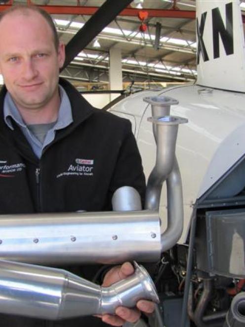 Performance Aviation director Matt Bailey holds a new Power Flow exhaust system for Robinson 22...