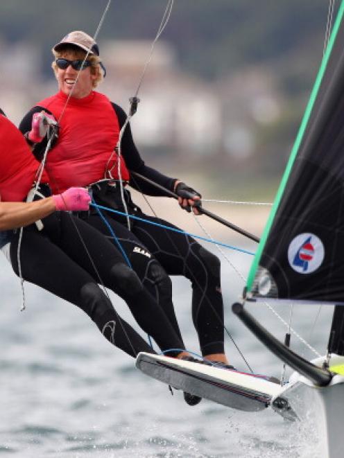 Peter Burling (R) and Blair Tuke of New Zealand cross the line during the 49er Class medal race...