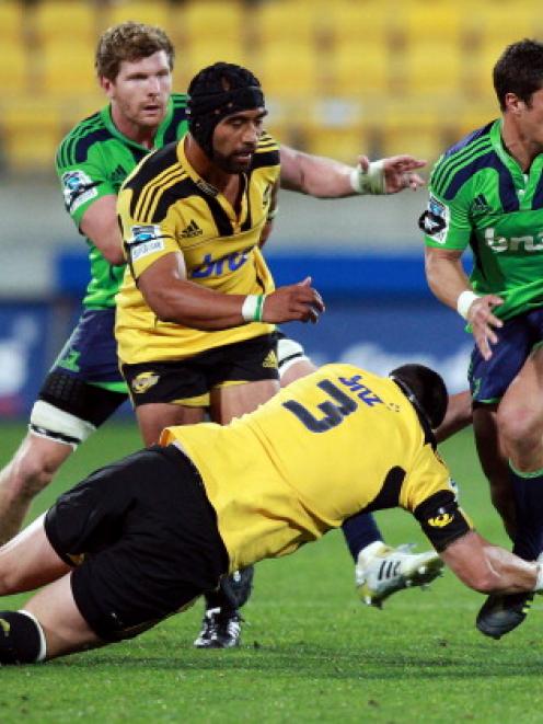 Phil Burleigh of the Highlanders is tackled by Jeffery Toomaga-Allan and Victor Vito (L) of the...