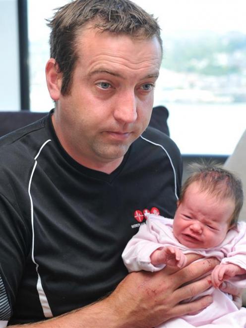 Phil Hudson, holds his 3-week-old daughter Hayley,  after chasing a burglar from his Vauxhall...