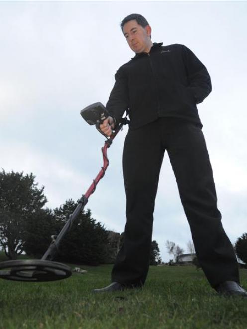 Phil Wheeler uses a metal detector in his effort to locate a buried time capsule at his former...