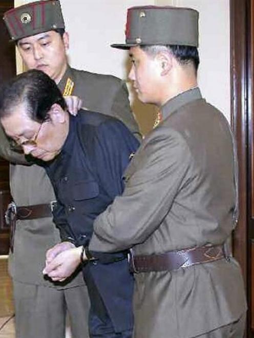 Jang Song-thaek, with his hands bound, is dragged into the court by uniformed personnel last week...