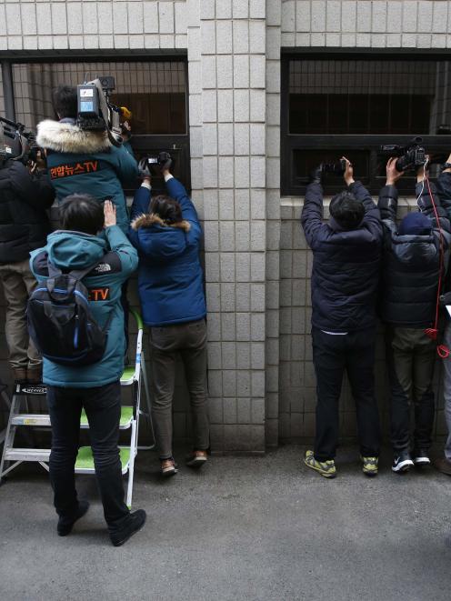 Photographers attempt to get images of a bus transporting Cho Hyun-ah, also known as Heather Cho,...