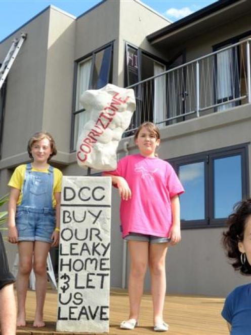 Pictured outside their leaky Glenleith home last February are  (from left) Michael Beazley,...
