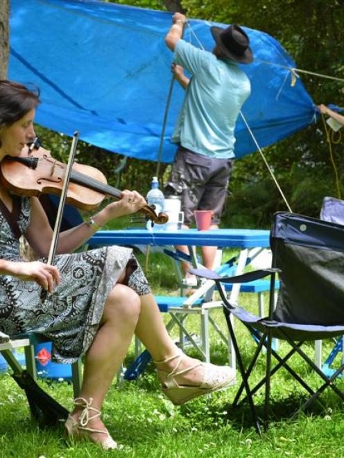 Playing a Scottish tune on the fiddle, performer Anna Bowen takes a break while her husband...