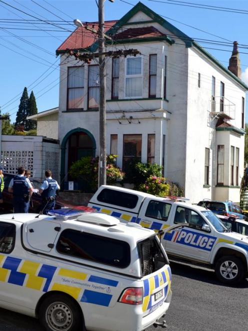 Police cars line the road outside a Duncan St, Dunedin, house where a female occupant was...
