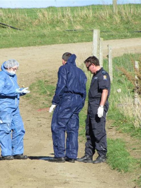 Police collect evidence from  the driveway at the home of alleged  murder victim Justin McFarlane...