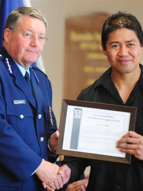 Police Commissioner Howard Broad awards security guard Tearoha Enoka with a certificate of...