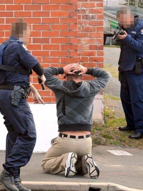 Police detain a man at a Pine Hill Rd property, following an eruption of gang violence in...