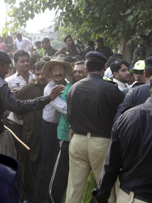 Police direct spectators outside Gaddafi stadium as they arrive to watch the first Twenty20...