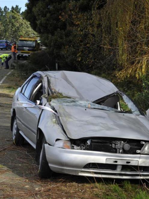 Police examine State Highway 1, near the Karitane turn-off, after a car was badly damaged by a...