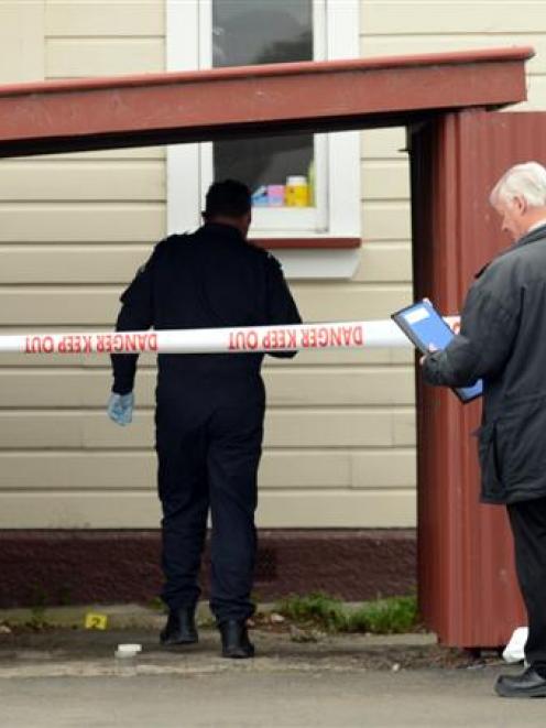 Police examine the scene of an alleged sexual assault at a South Dunedin property yesterday...